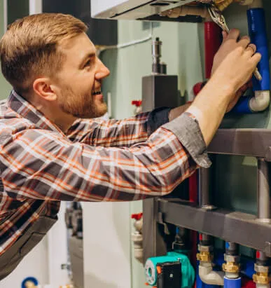 Technicien de Maes Débouchage réparant une canalisation