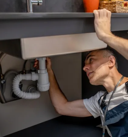 Technicien inspectant une canalisation sous un évier