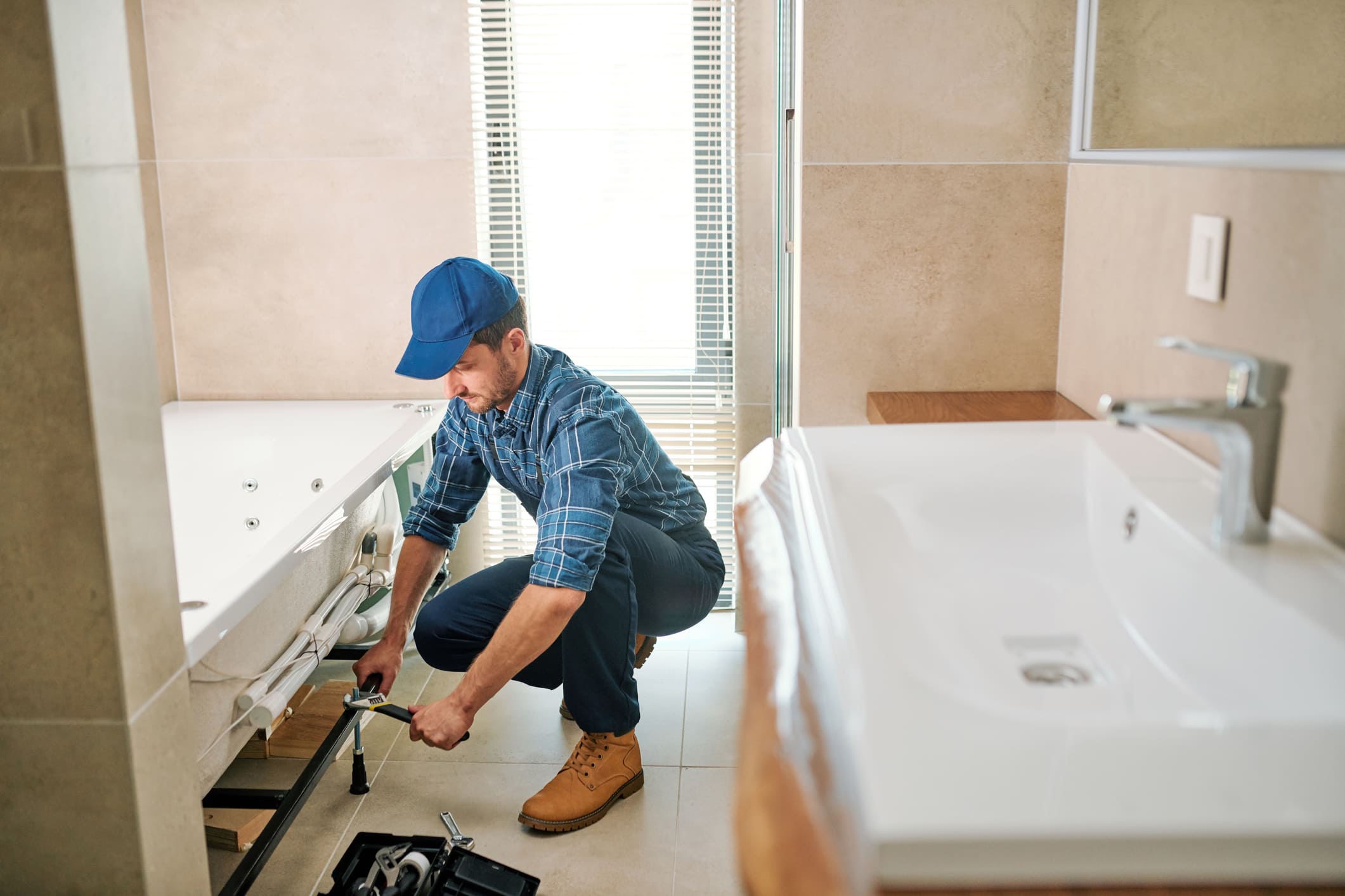 Plombier professionnel installant une baignoire balnéo dans une salle de bain moderne et lumineuse