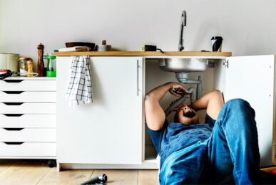 Un professionnel répare une canalisation sous un évier