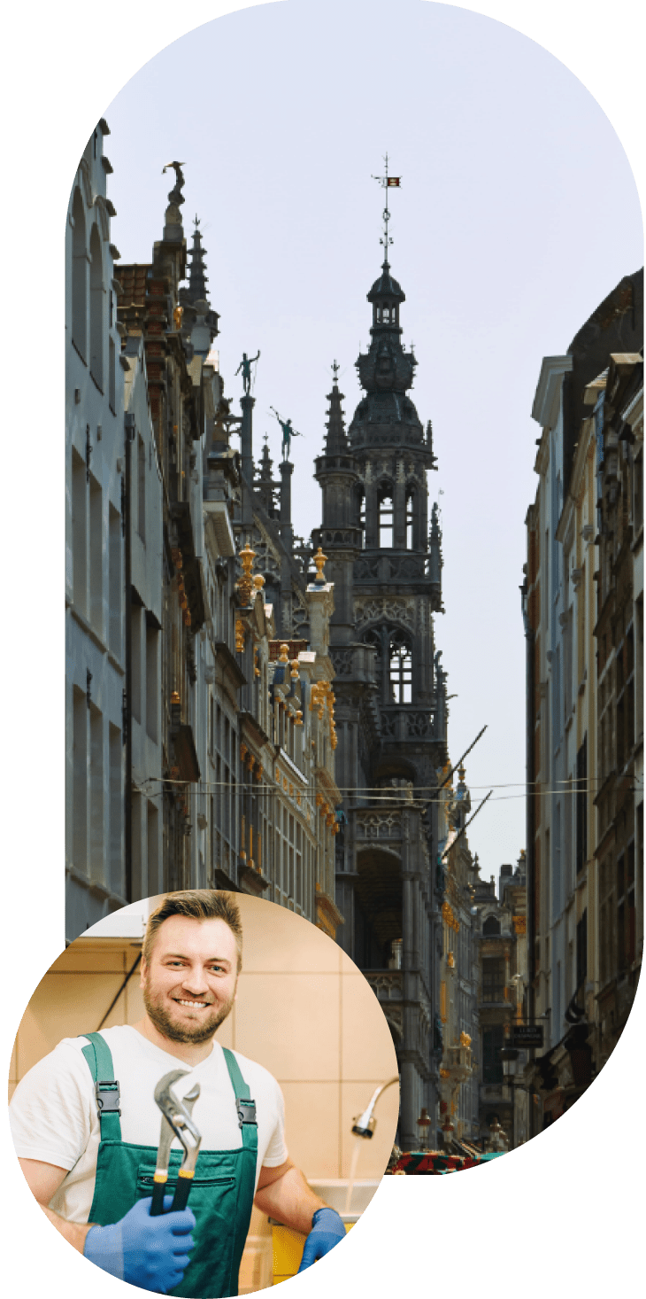 Plombier souriant tenant une clé à molette devant une cuisine, avec une rue de Bruxelles en arrière-plan.