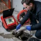 technicien noir inspectant canalisation camera dinspection 85x85